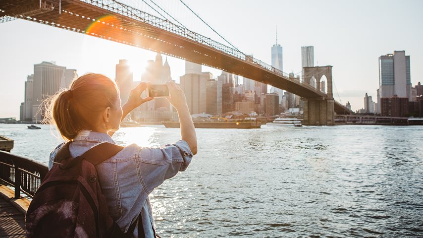 Kvinde tager billede af bro i New York